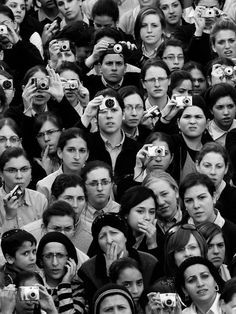 a large group of people taking pictures with their cameras