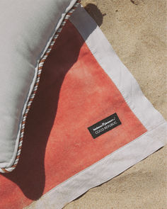 Close-up shot of a beach towel with a coral and white color scheme, featuring the Business & Pleasure Co. x Coco Republic logo. The detail highlights the quality and craftsmanship of the towel, perfect for a luxury beach experience. Stylish Throw Pillows