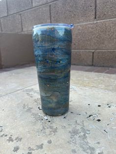 a blue cup sitting on top of a cement floor