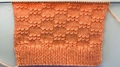 an orange piece of yarn sitting on top of a white table next to a wall