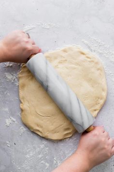 a person rolling out dough on top of a table