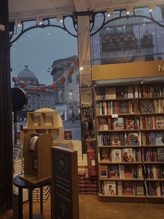 an open book store with lots of books on the shelves and in front of a window