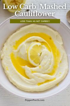 low carb mashed cauliflower in a white bowl with lemon wedges