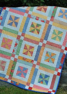 a multicolored quilt on a stone wall