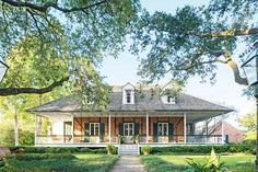 a large brick house sitting on top of a lush green field