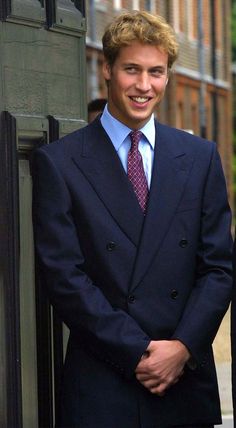 a man in a suit and tie standing next to a building