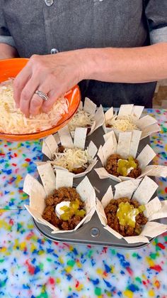 a person preparing food on top of a table next to an orange bowl filled with rice