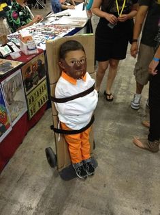 a young boy in an orange and white shirt is standing on a skateboard wearing goggles