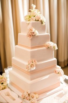 a white wedding cake with flowers on it