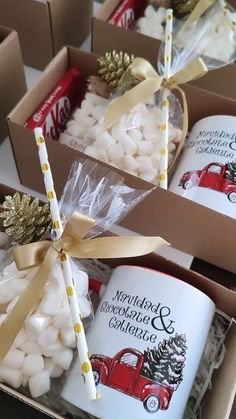 two coffee mugs and some marshmallows are in a box with ribbon