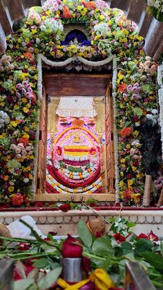 an elaborately decorated shrine with flowers on the wall