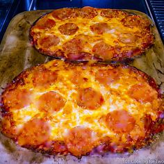 two pepperoni pizzas sitting on top of an oven