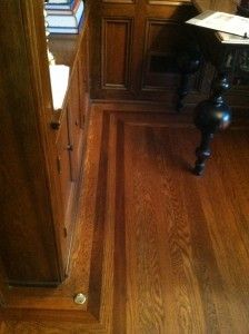 a room with wood floors and wooden cabinets