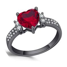 a heart shaped ruby and diamond ring with two diamonds on the sides, set in black gold