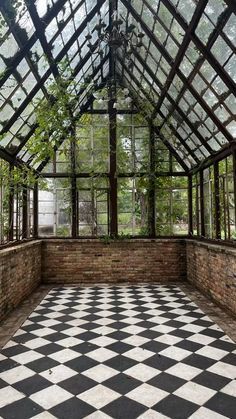 the inside of a glass house with black and white checkerboard flooring in it