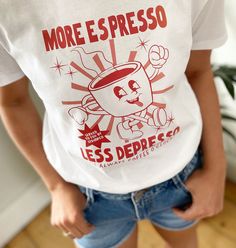 When coffee is life! A funny gift for that coffee lover friend or family member. A cool retro design slogan t shirt.  Each design is individually hand printed to order. The model is a size 8 and is wearing an extra small.  100% Organic Cotton Environmentally friendly 🌱 Our t-shirts are a unisex fit. If you would like a more fitted look we would recommend going down a size. Please see our size guide displayed in the photos. Model is 5'10 and is wearing a small navy T-shirt with white print. Machine wash inside out at 30. Do not tumble dry or iron the print. HOW TO LOOK AFTER ME Machine wash inside out at 30. Do not tumble dry or iron the print. FOLLOW OUR SOCIAL AND TAG US USING #SYDANDCO TO FEATURE More Espresso Less, Cool Slogans, Slogan Tshirt, Slogan T Shirt, Coffee Is Life, Retro Cartoons, Coffee Shirts, Retro Shirts