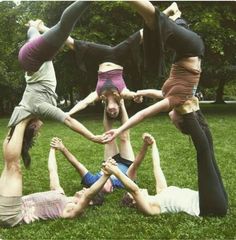 a group of people standing in the middle of a circle on top of each other