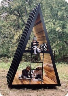 a group of people sitting on top of a wooden structure in the woods with animals