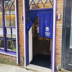 an open door to a building with a blue banner hanging from it's side