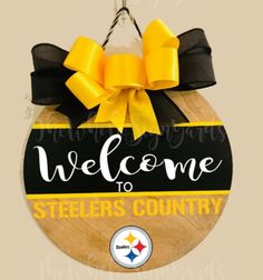 a wooden sign that says welcome to steele's country with a black and yellow bow