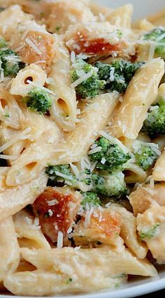 a pasta dish with broccoli, tomatoes and parmesan cheese on top