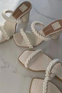 three pairs of shoes with pearls on them