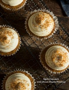 six cupcakes with cream cheese frosting on a cooling rack, top view