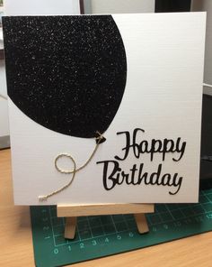 a birthday card with a black balloon on it