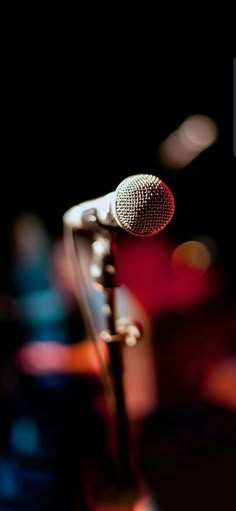 a microphone that is sitting on top of a stand in front of some blurry lights