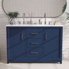 a bathroom vanity with two sinks and a round mirror above it, in front of a white brick wall