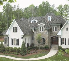 a large white house with black shutters and two story windows on the front of it