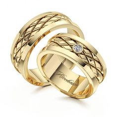 two yellow gold wedding bands with diamonds on each side and an engraved diamond in the center