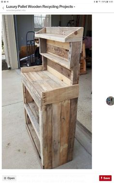 a wooden bench made out of pallets on the side of a building with an open door