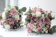 two bridal bouquets sitting on top of a white table next to each other