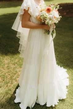 a woman in a wedding dress holding a bouquet