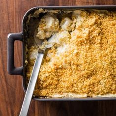 a casserole dish filled with macaroni and cheese on a wooden table