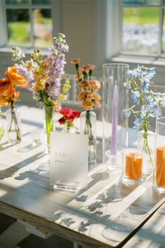 vases filled with flowers sitting on top of a wooden table