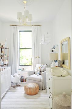 a baby's room is decorated in white and neutrals with pops of color