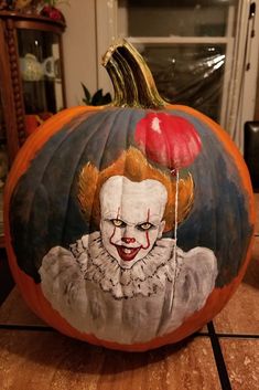 a painted pumpkin with a clown face on it