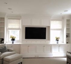 a living room filled with furniture and a flat screen tv mounted to the side of a wall