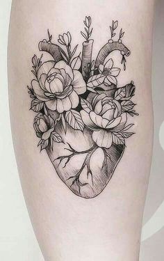 a black and white photo of a heart shaped tattoo with flowers on the inside of it