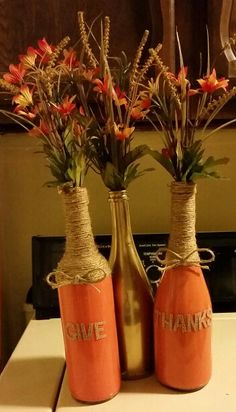 two vases with flowers in them sitting on a table