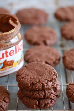 chocolate cookies cooling on a rack next to a jar of nutella