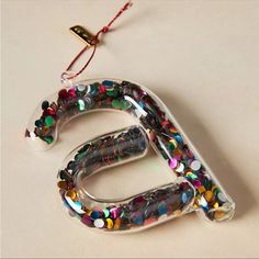 the letter e is decorated with multicolored beads