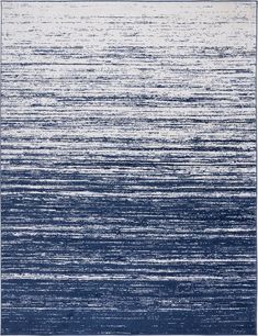 a rug with blue and white stripes on the bottom, in front of an ocean background