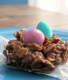 a blue plate topped with two cookies and candy eggs on top of each other next to an easter egg