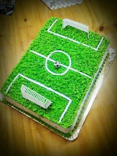 a cake that looks like a soccer field with grass on top and white trim around the edges