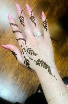 a woman's hand with henna tattoos on it