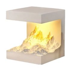 a white table with a mountain scene on the top and yellow light coming from it