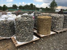 several stacks of rocks sitting on pallets in the dirt